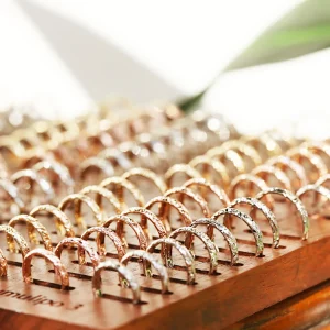 プアアリのブライダルリングが木製の指輪ケースに沢山並べられている